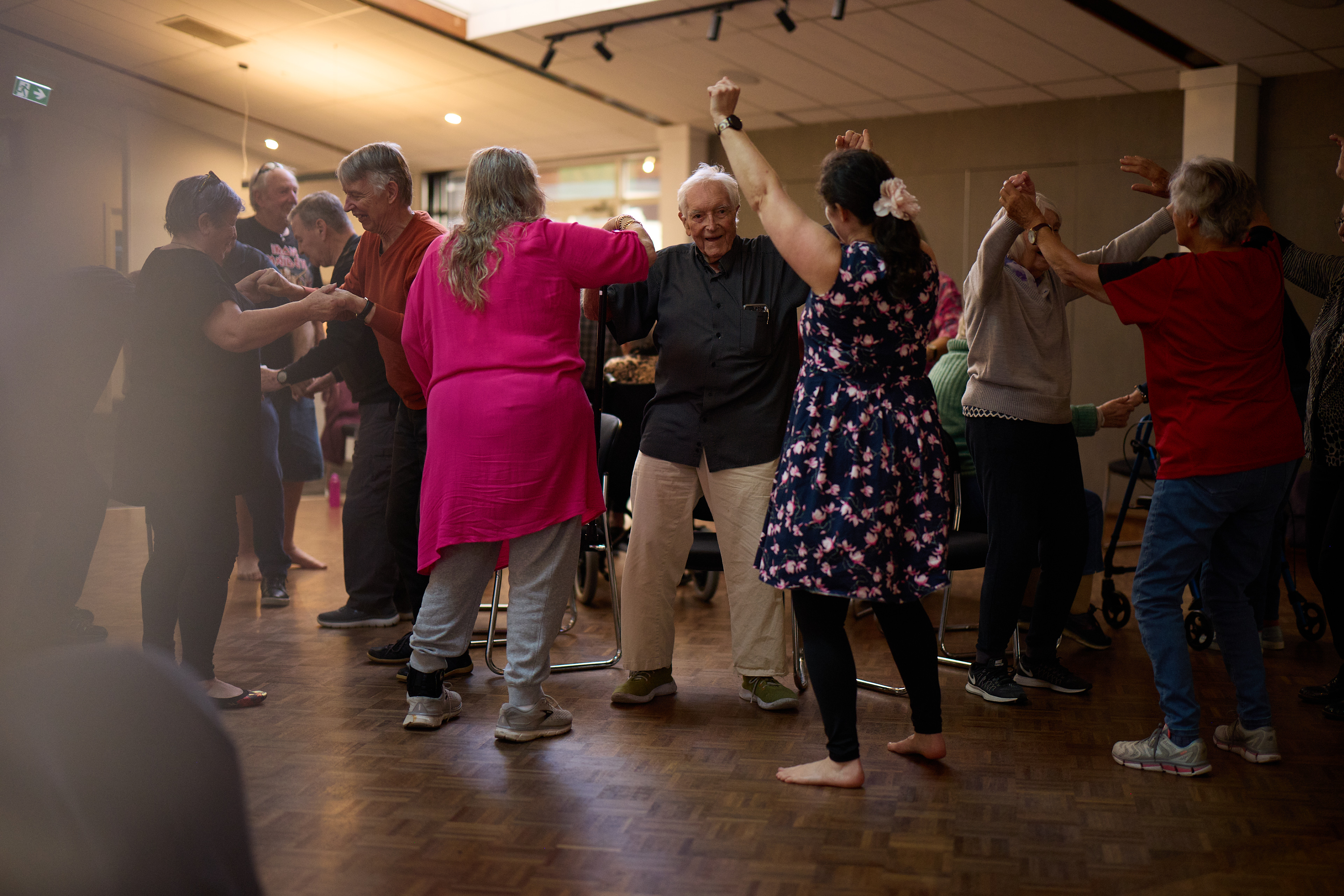 An older woman holding a walking aid and an older man standing in a doorway 